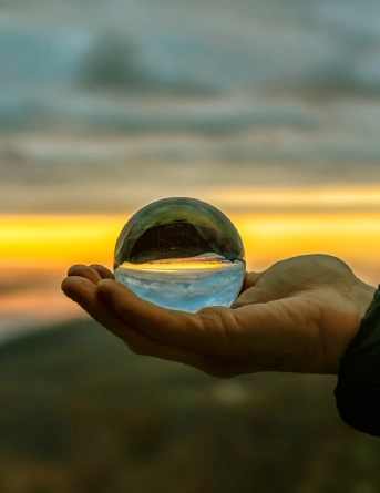 Plano aproximado de uma mão a segurar numa bola de cristal